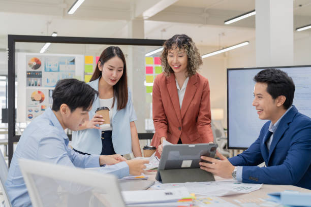 istock Creative Asian professionals brainstorming in a modern office. Business team collaborating on innovative ideas and strategies in a contemporary workspace, emphasizing teamwork and dynamic thinking 2165389734