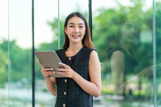 istock Young Businesswoman Using A Tablet, Looking At Camera 2165389819