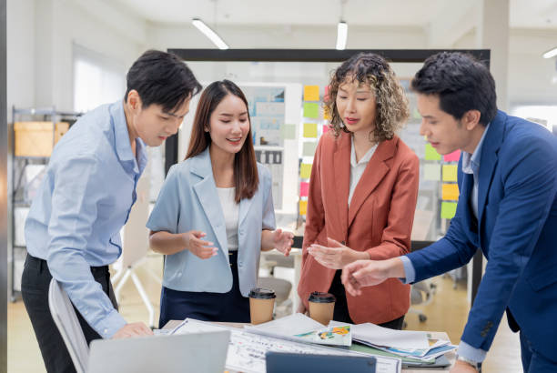 istock Creative Asian professionals brainstorming in a modern office. Business team collaborating on innovative ideas and strategies in a contemporary workspace, emphasizing teamwork and dynamic thinking 2165389828