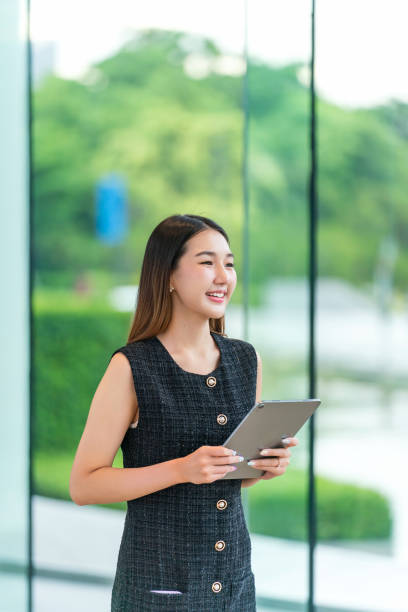 istock Young Businesswoman Using A Tablet, Looking Away Smiling 2165389961