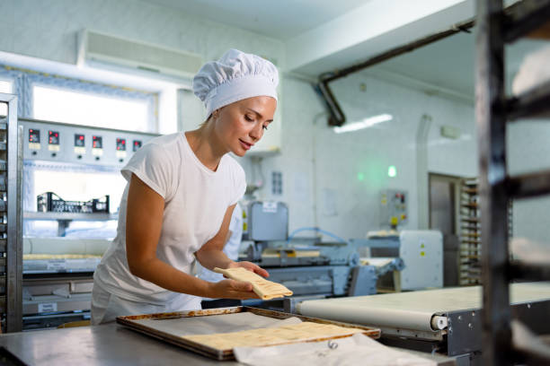 istock Person folding dough on baking tray in professional kitchen. 2165392567