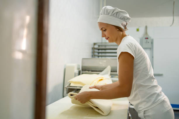 istock Baker shaping dough on counter with focus on precision 2165392710