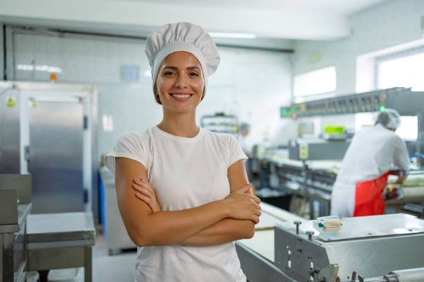 istock Confident female baker smiling with arms crossed 2165393598