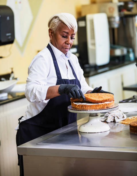 istock Senior black woman making cake in bakery 2165396693