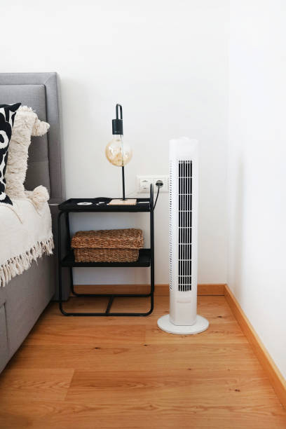 istock White tower fan next to pillows in a modern interior 2165398461