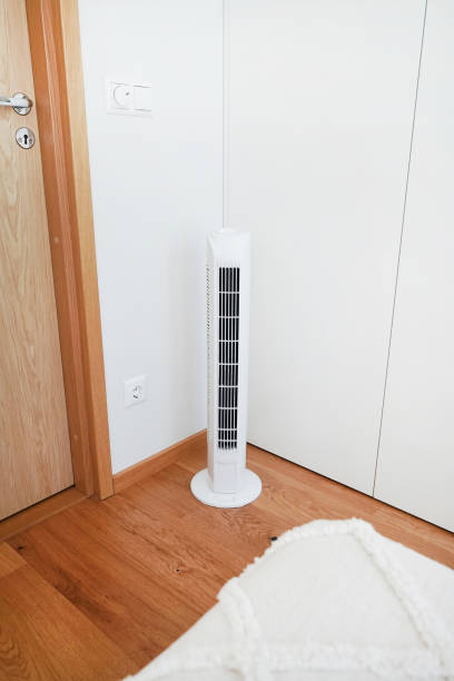 istock White tower fan next to pillows in a modern interior 2165398574