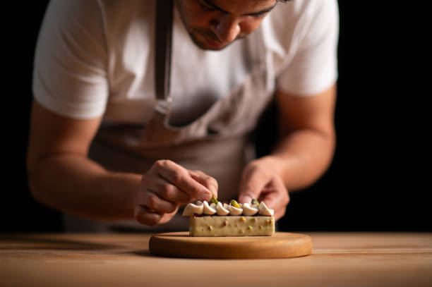 istock A male pastry chef decorating a cake with pistachios 2165398662
