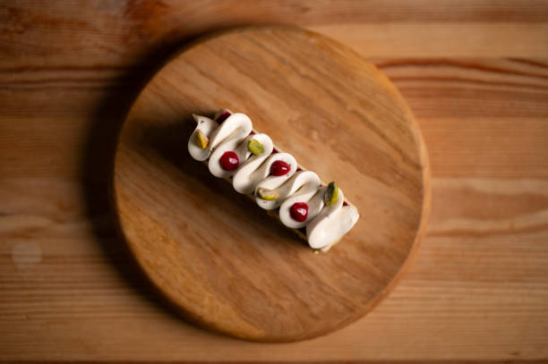 A cake with pistachios on a wooden plate.