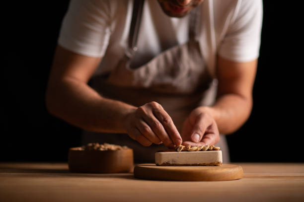 istock A male pastry chef making a cake with peanuts 2165398777