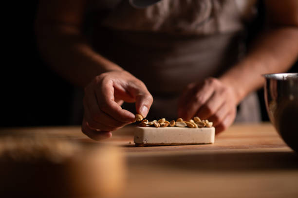 A male pastry chef making a cake with peanuts