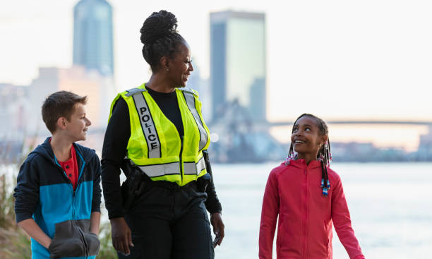 istock Policewoman walking, talking with children in community 2165398923