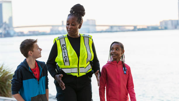 istock Policewoman walking, talking with children in community 2165398930