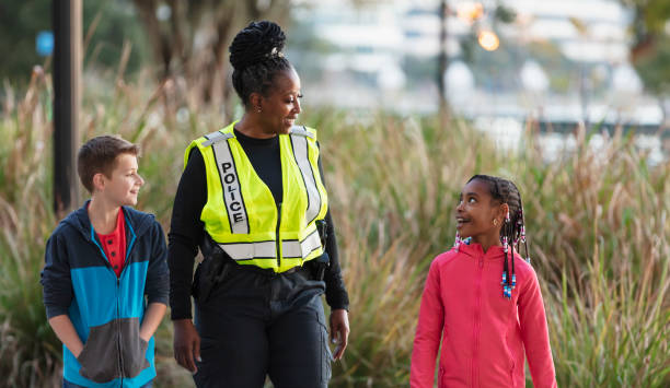 istock Policewoman walking, talking with children in community 2165398931