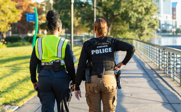 istock Two policewomen patrolling a city park on foot 2165398964