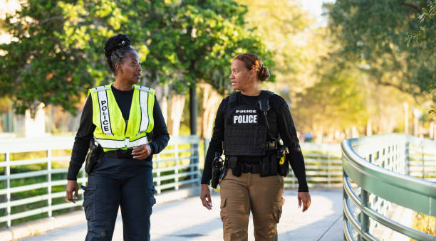 istock Two policewomen patrolling a city park on foot 2165398978