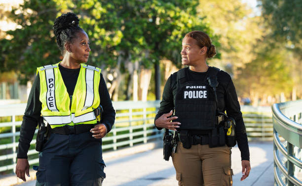 istock Two policewomen patrolling a city park on foot 2165398979
