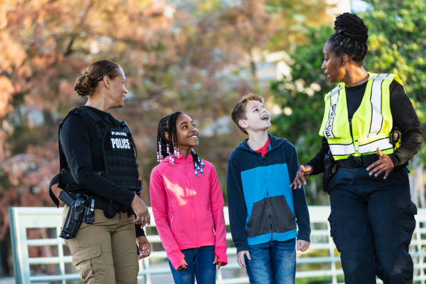 istock Two policewomen talking with children in city park 2165399009