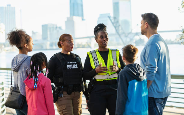 Policewomen talking on city waterfront with two families