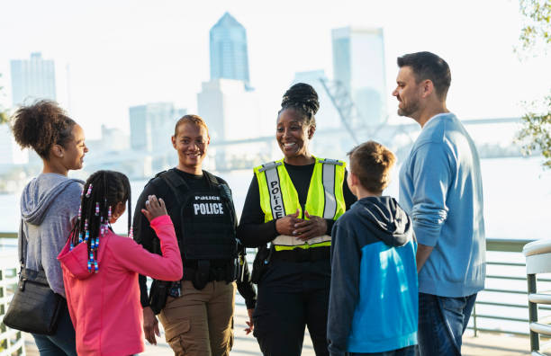istock Policewomen talking on city waterfront with two families 2165399091