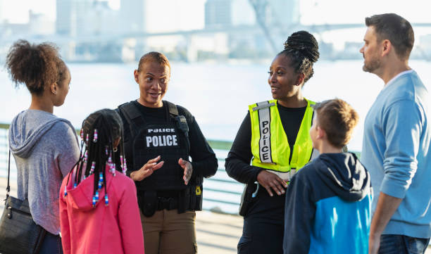 istock Policewomen talking on city waterfront with two families 2165399092