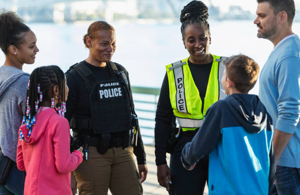 istock Policewomen talking on city waterfront with two families 2165399102