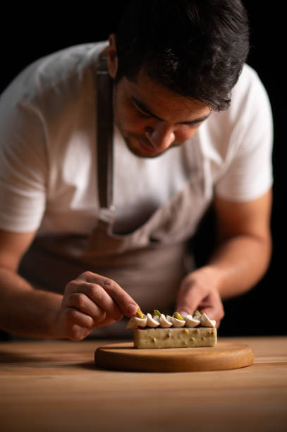 istock A male pastry chef decorating a cake with pistachios 2165399289