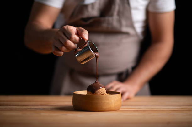 istock A male pastry chef pouring chocolate sauce on profiteroles 2165399701