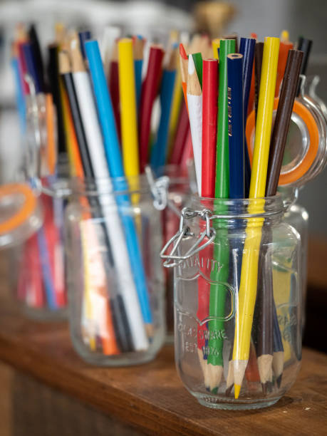 istock Colorful Pencils in Glass Jars on Wooden Surface 2165400516