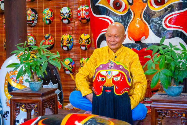 artisan making handmade antique masks in Hoi An ancient town, Quang Nam, Vietnam Quang Nam province, Vietnam - 13 Jul 2024: artisan making handmade antique masks in Hoi An ancient town, Quang Nam, Vietnam vietnamese old man portrait stock pictures, royalty-free photos & images