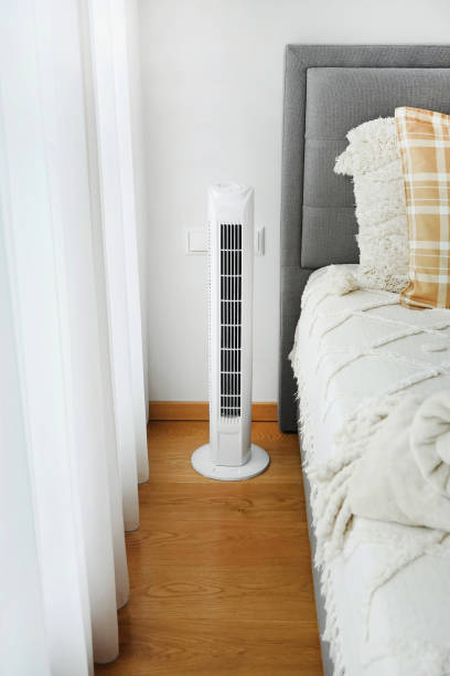 istock White tower fan next to the bed in a modern bedroom 2165402396
