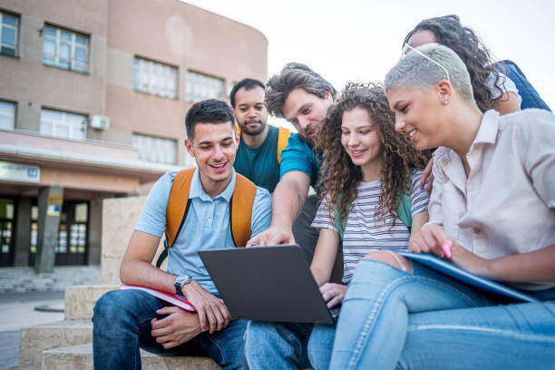 istock Group of students gathers around a laptop 2165404985