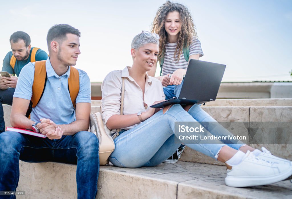 Student Read Notes Young Students Read Notes On Laptop Stock Photo - Download Image Now ...