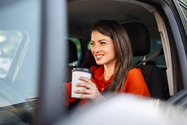 istock Smiling businesswoman in the car drinking coffee going to work 2165407940