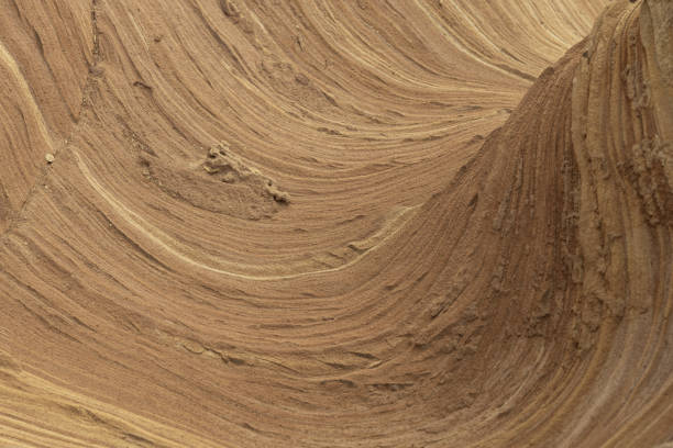 Close-up of intricate sandstone swirls and erosion patterns, highlighting the natural beauty and texture of sedimentary rock formations. Perfect for geological themes and backgrounds.