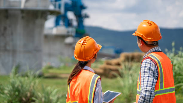 istock Survey team is working with a theodolite and road construction plans. Civil engineers are taking measurements with surveying tools during the construction. 2165409579