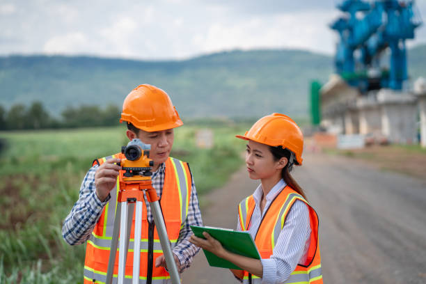 istock Survey team is working with a theodolite and road construction plans. Civil engineers are taking measurements with surveying tools during the construction. 2165409717