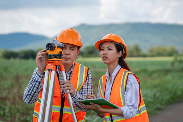 istock Survey team is working with a theodolite and road construction plans. Civil engineers are taking measurements with surveying tools during the construction. 2165409729