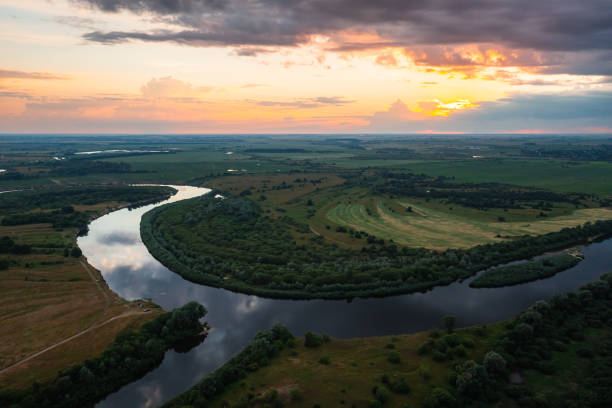 istock An aerial view showcasing a breathtaking sunset over a river that gracefully winds through a lush landscape 2165410614