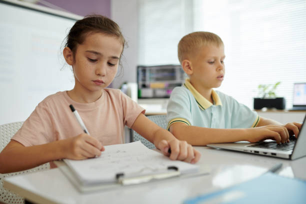 istock Children Concentrating on Homework in Modern Classroom Setting 2165410970