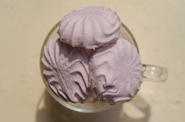 The pink marshmallow in glass tea cup on beige background. High quality photo