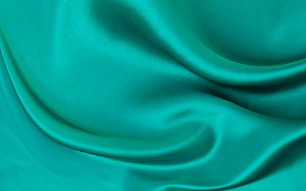 istock Black green satin dark fabric texture luxurious shiny that is abstract silk cloth background with patterns soft waves blur beautiful. 2165416540