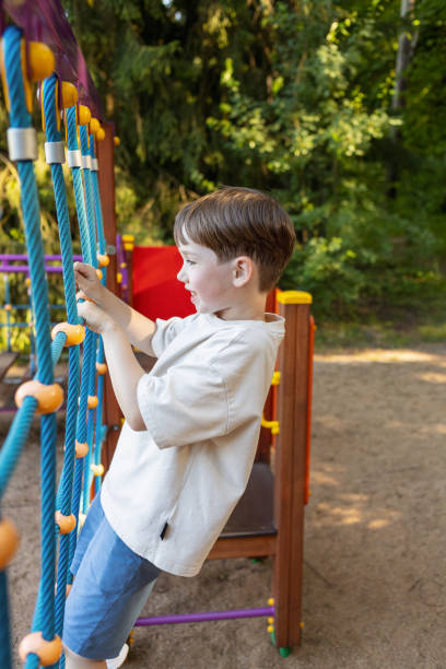 istock 6 year old boy playing on a children's playground 2165416563