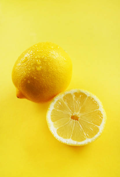 istock Whole and cut lemons on a yellow background 2165419641