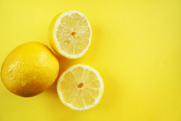 istock Whole and cut lemons on a yellow background 2165419647