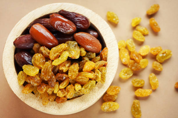 istock Dried dates and raisins in a wooden plate 2165419705