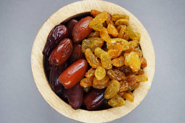 istock Dried dates and raisins in a wooden plate 2165419735