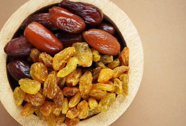 istock Dried dates and raisins in a wooden plate 2165419739