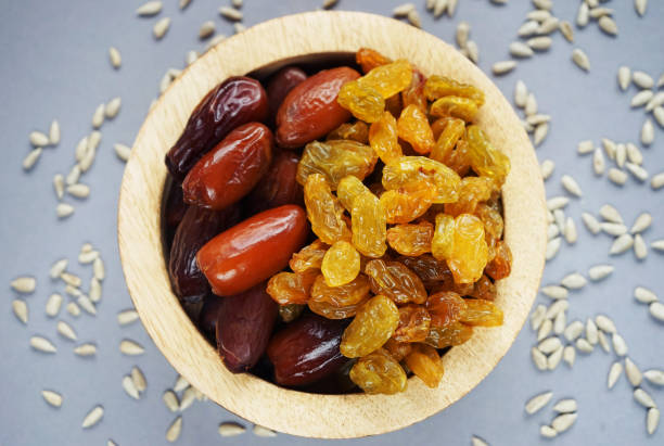 istock Dried dates and raisins in a wooden plate 2165419740