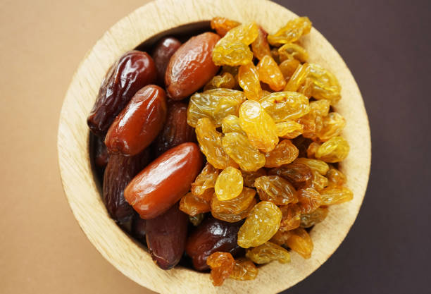 istock Dried dates and raisins in a wooden plate 2165420297