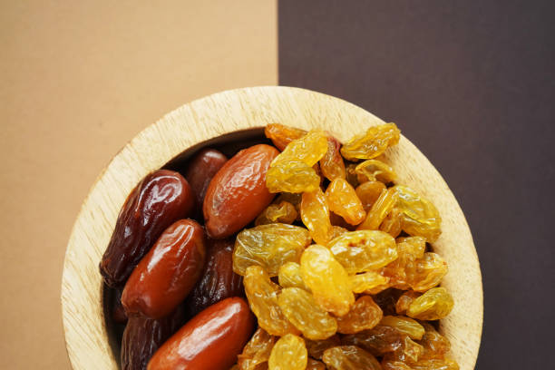 istock Dried dates and raisins in a wooden plate 2165420306